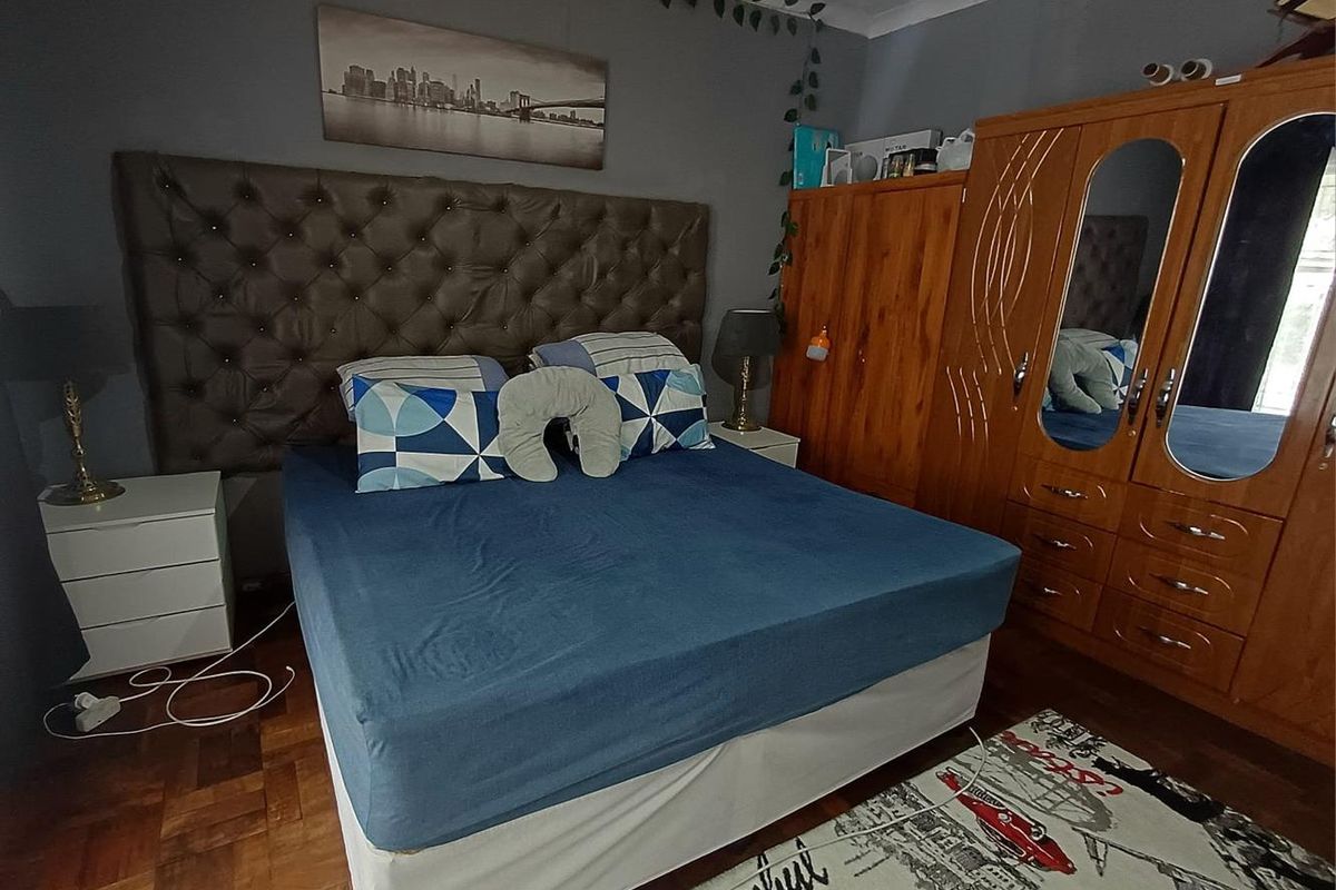 A bedroom featuring parquet flooring and a coved ceiling, providing a functional space for rest.