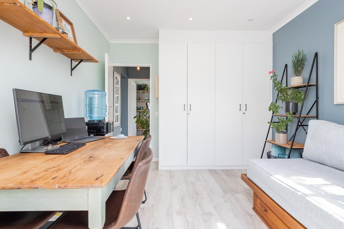 A well-maintained bedroom featuring built-in wardrobes, recessed lighting, and light-toned laminate flooring, offering a functional and bright living space.