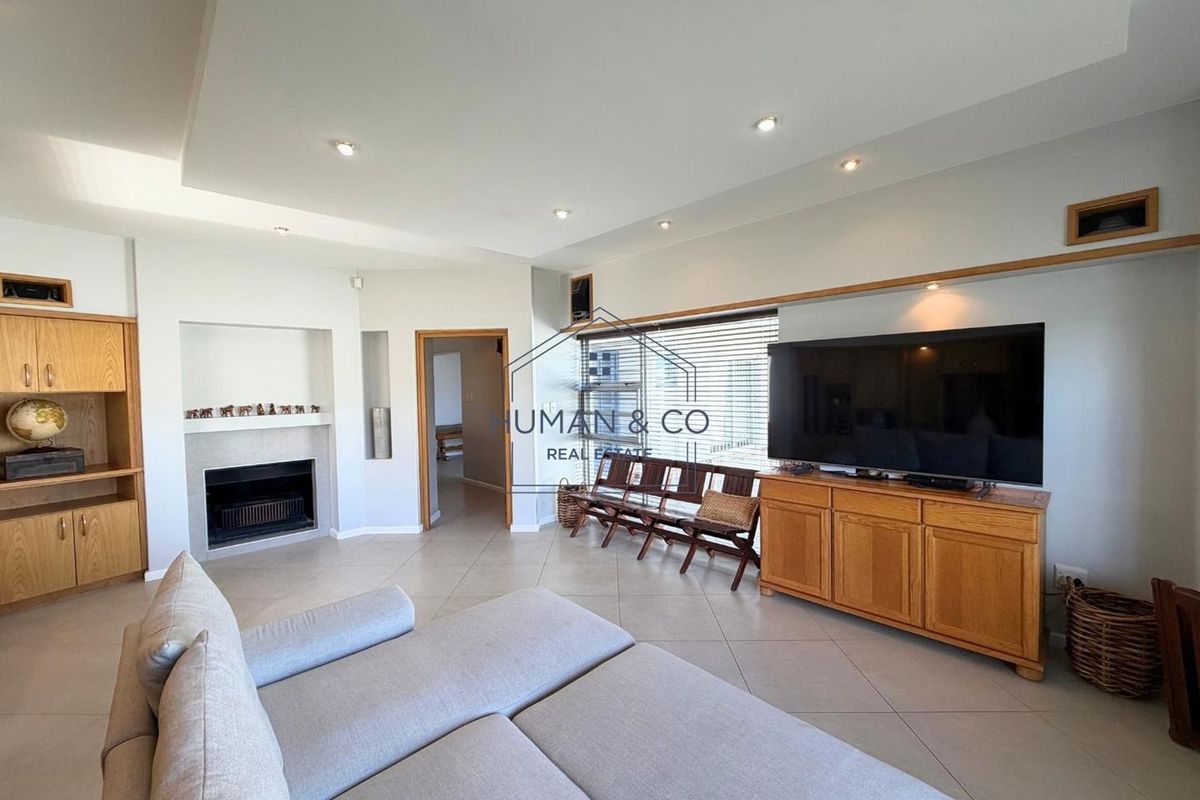 Spacious living room featuring tiled flooring, recessed ceiling lights, a built-in fireplace, and custom wooden cabinetry.