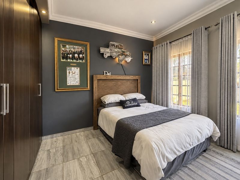 A well-maintained bedroom featuring tiled flooring, built-in cupboards, and recessed downlighting, offering a clean and modern aesthetic.