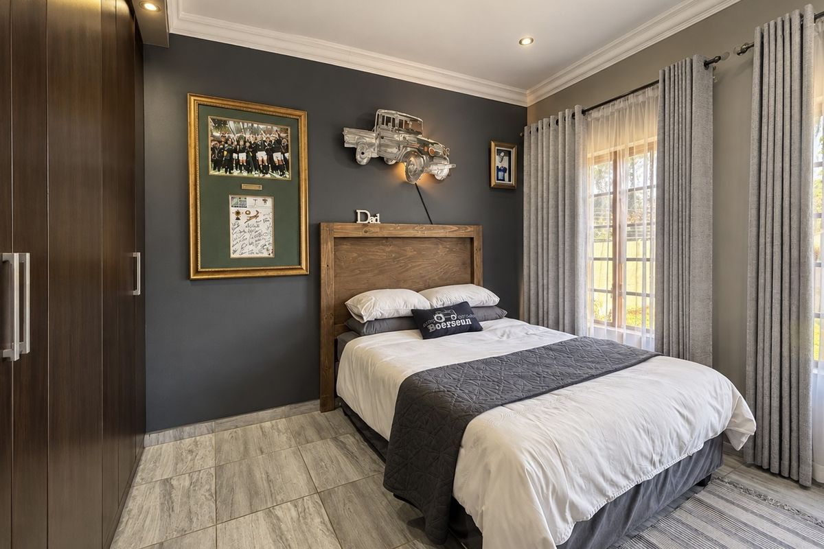 A well-maintained bedroom featuring tiled flooring, built-in cupboards, and recessed downlighting, offering a clean and modern aesthetic.