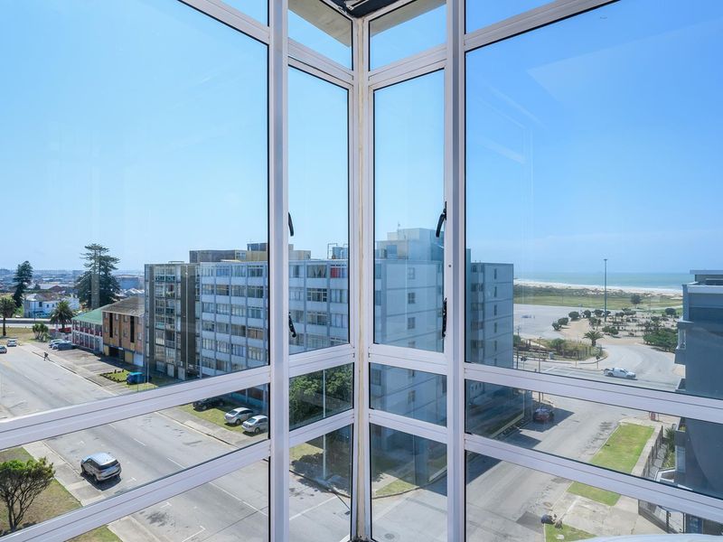 A clear view of the surrounding urban landscape and coastline captured through a modern corner window installation.