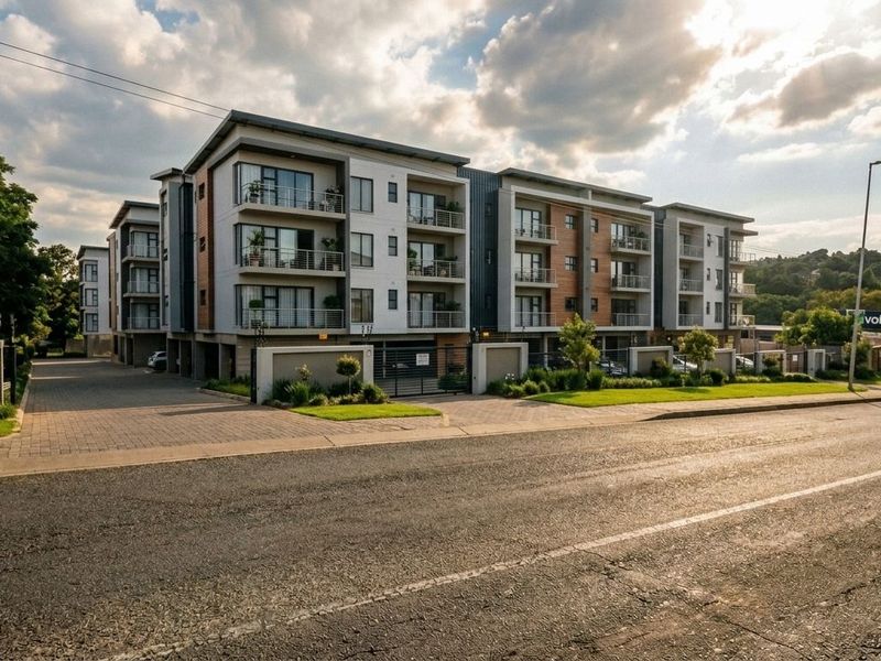 A modern multi-story apartment complex featuring contemporary facade design, private balconies, secure gated access, and well-maintained landscaped grounds.