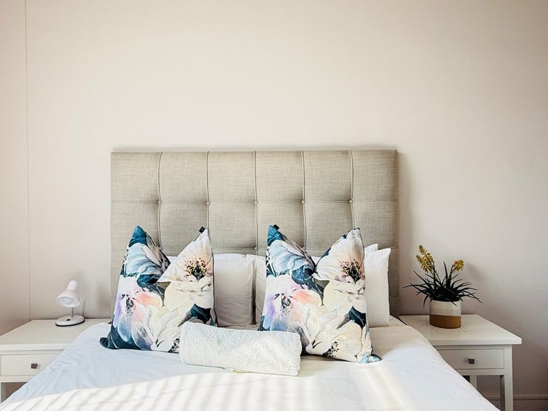 A well-lit bedroom featuring neutral wall tones and a clean, minimalist aesthetic.