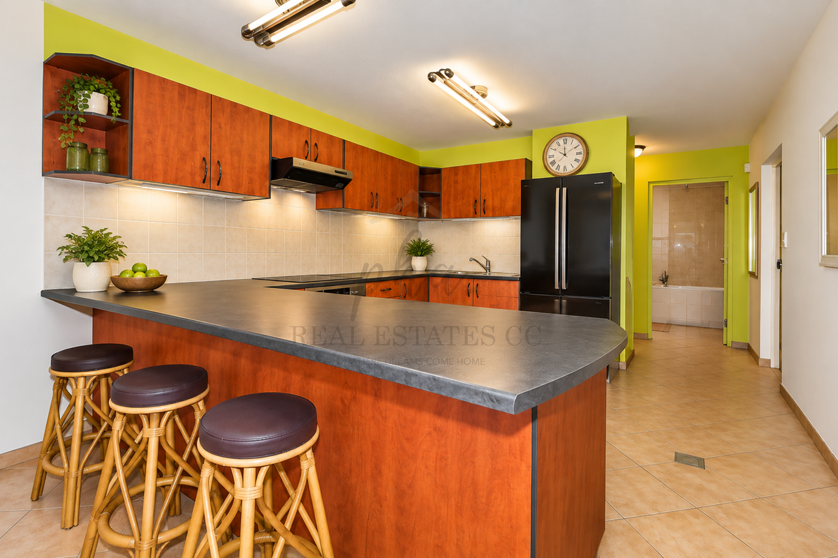 A functional kitchen featuring wood-tone cabinetry, a breakfast bar, tiled backsplash, and integrated appliances, leading to a hallway and bathroom area.