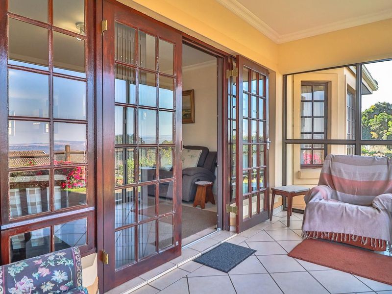 A covered patio area featuring tiled flooring and large wooden-framed glass sliding doors that provide seamless access to the interior living space.
