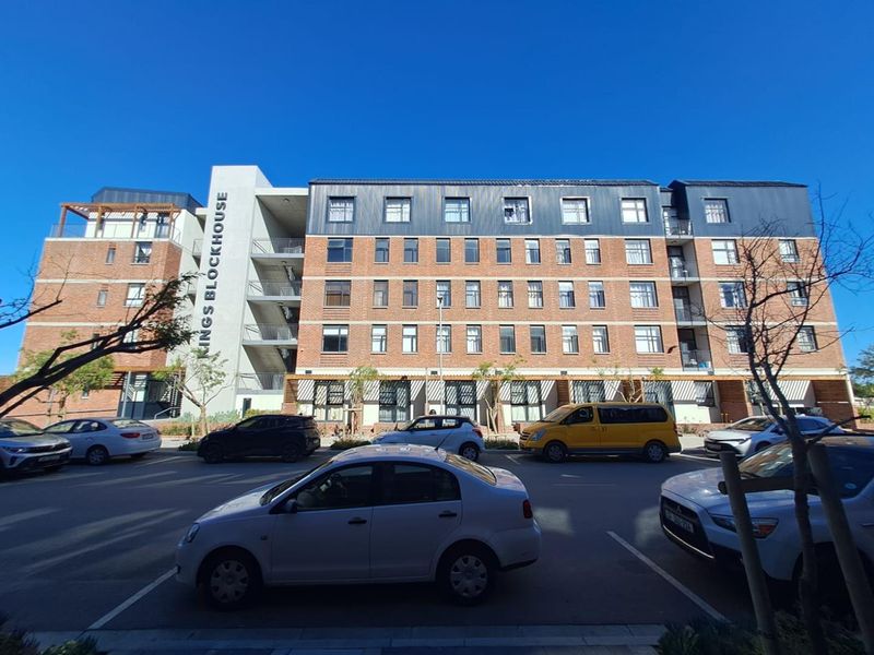 Front elevation of the Kings Blockhouse apartment building featuring a brick facade, metal roofing, and integrated balconies.