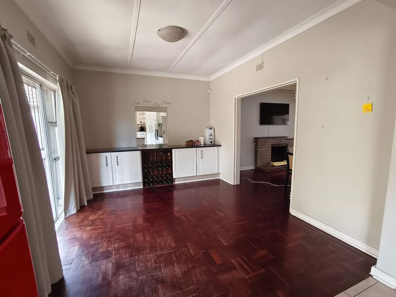 Living area featuring classic parquet flooring, built-in cabinetry with integrated wine storage, and direct access to the exterior via sliding glass doors.