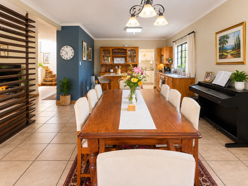 Spacious open-plan dining area featuring tiled floors, a decorative timber slat divider, and a functional kitchen with built-in wooden cabinetry.