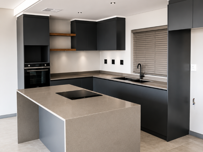 Modern kitchen featuring dark cabinetry, stone countertops, a central island with an integrated cooktop, and high-quality built-in appliances.