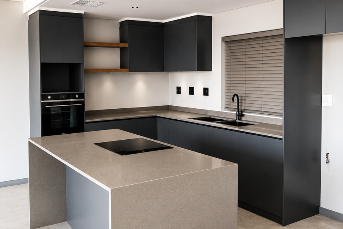 Modern kitchen featuring dark cabinetry, stone countertops, a central island with an integrated cooktop, and high-quality built-in appliances.