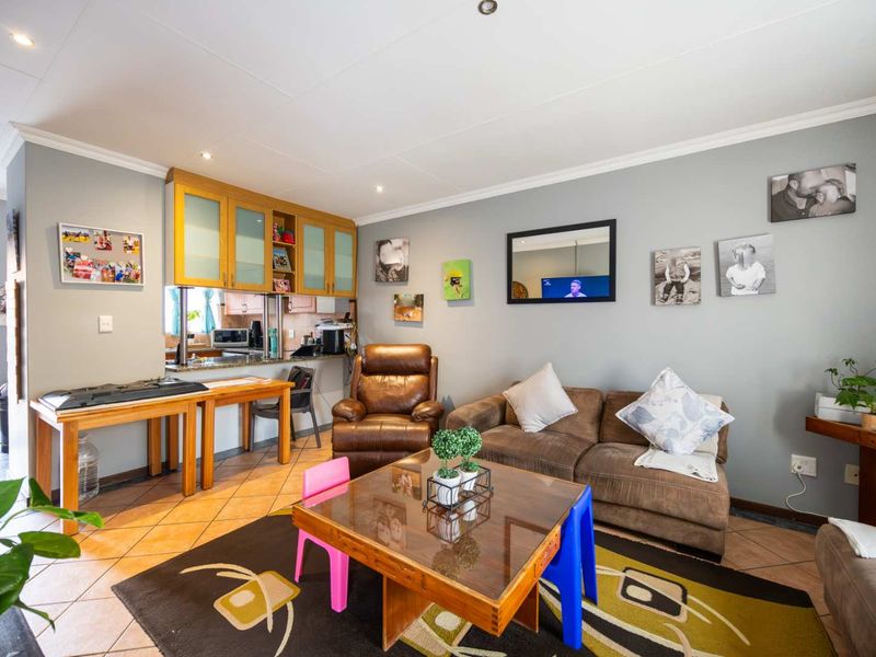 Open-plan living area featuring tiled flooring, recessed lighting, and a functional kitchen with granite countertops and a convenient pass-through window.