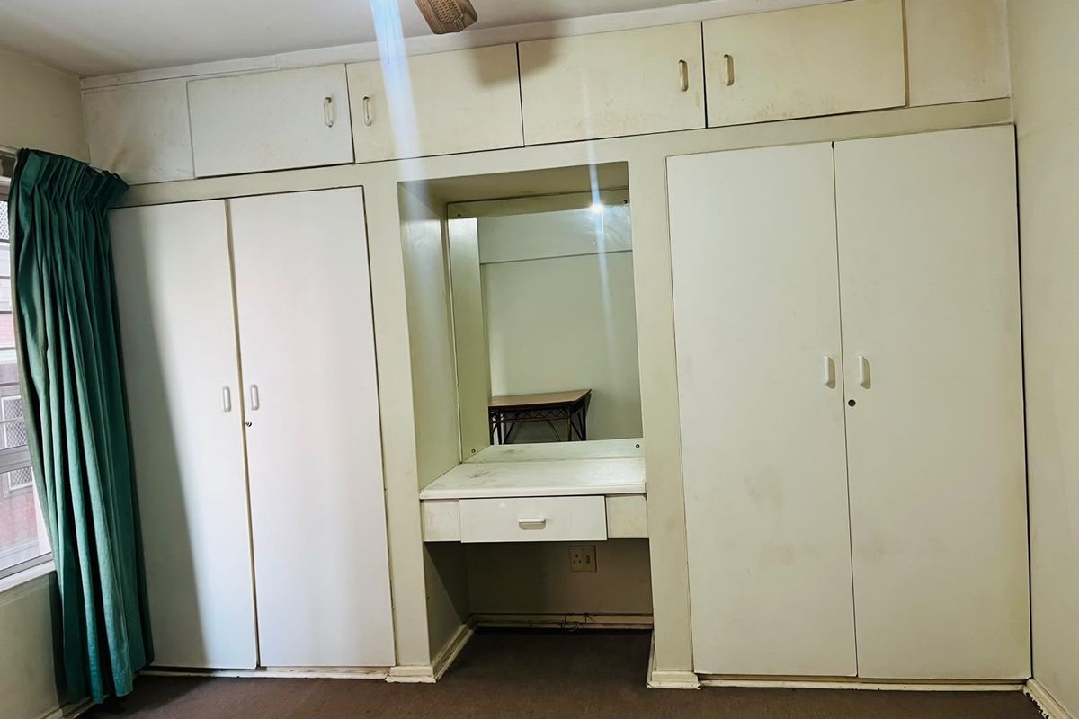 Bedroom featuring extensive built-in cabinetry with integrated vanity and overhead storage, providing ample storage space.
