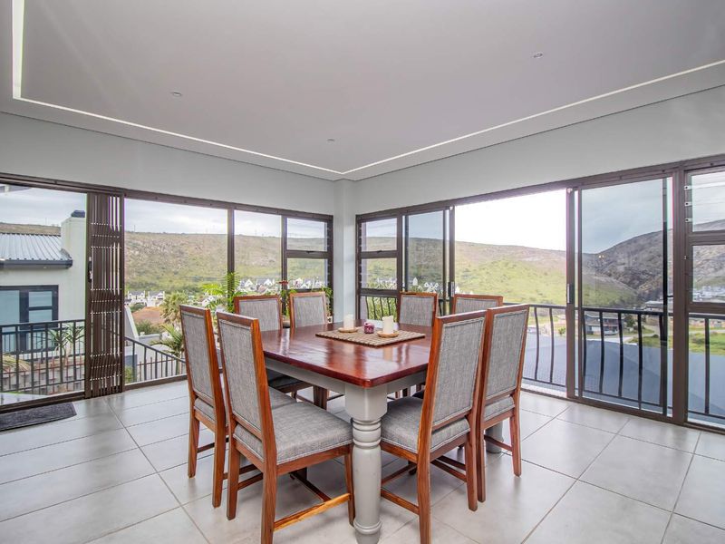 Bright dining area featuring large sliding glass doors that offer expansive mountain views and provide seamless access to the balcony.