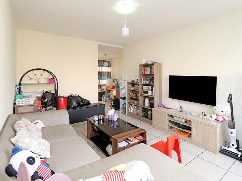 A living room area featuring tiled flooring and neutral wall finishes, providing a functional space for relaxation.