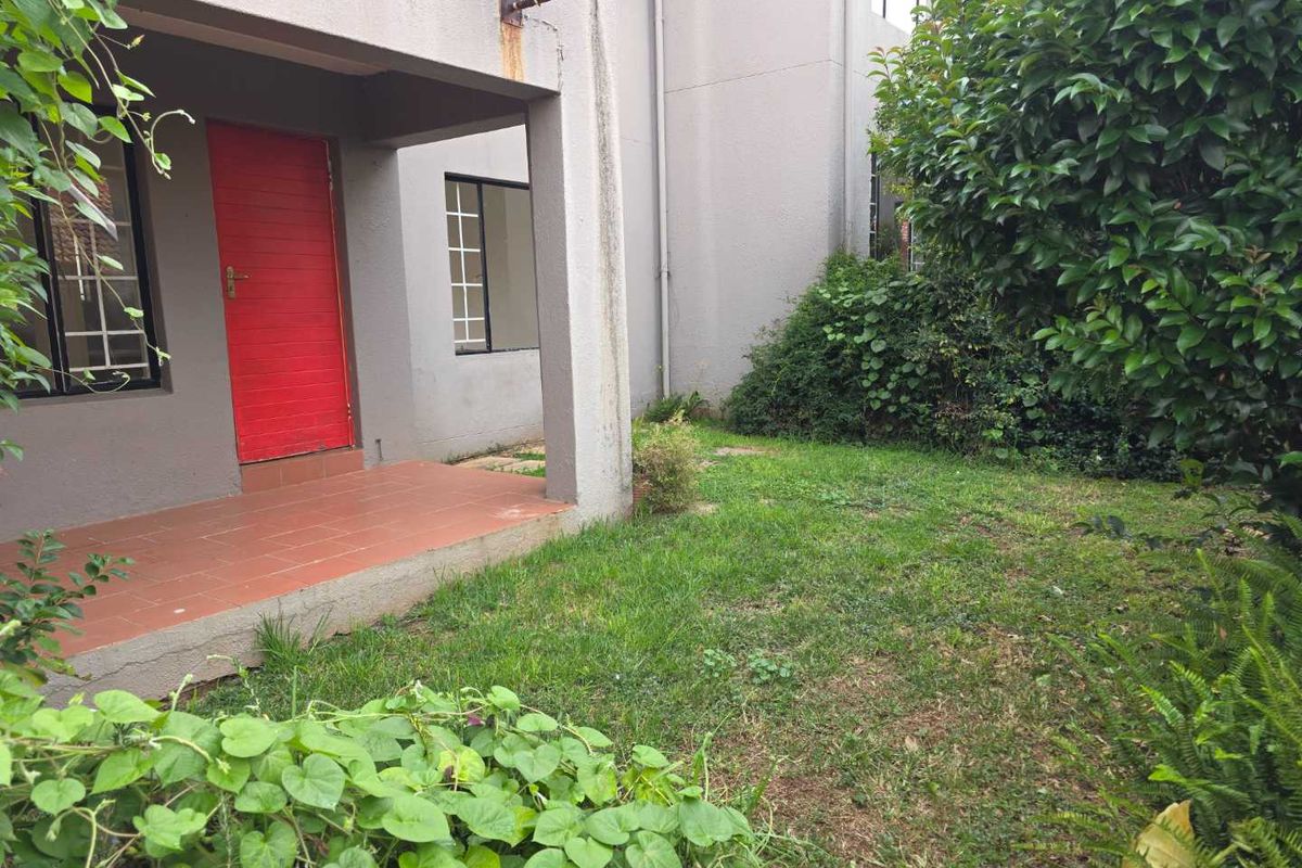 A private ground-floor entrance featuring a covered patio area and a small adjacent garden space.