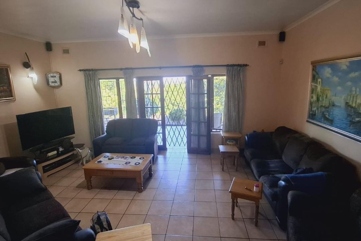 Spacious living room featuring tiled flooring and direct access to the outdoor area through classic french doors.