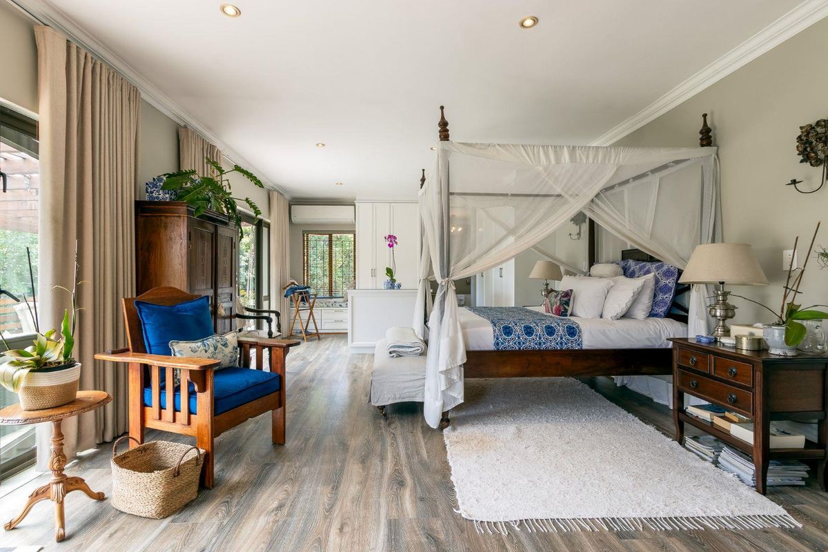 Spacious bedroom featuring wood-look flooring, recessed ceiling lighting, built-in cabinetry, and large sliding glass doors providing access to the exterior.