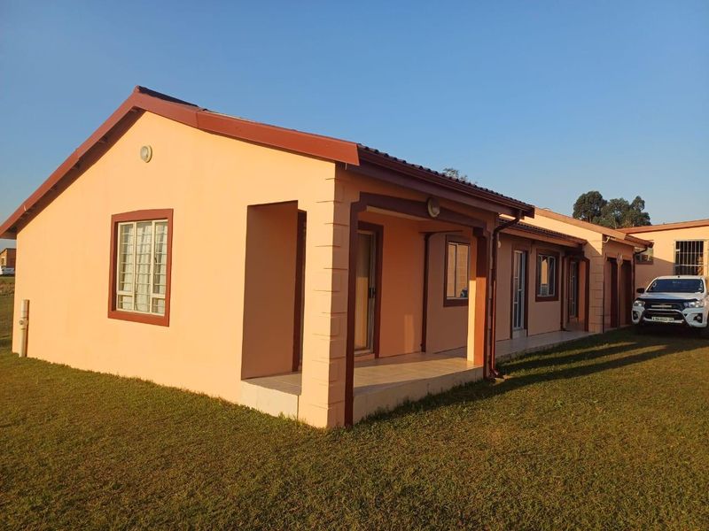 A well-maintained single-story residential house featuring a covered patio, tiled roof, and secure window fittings, set on a spacious lawn.