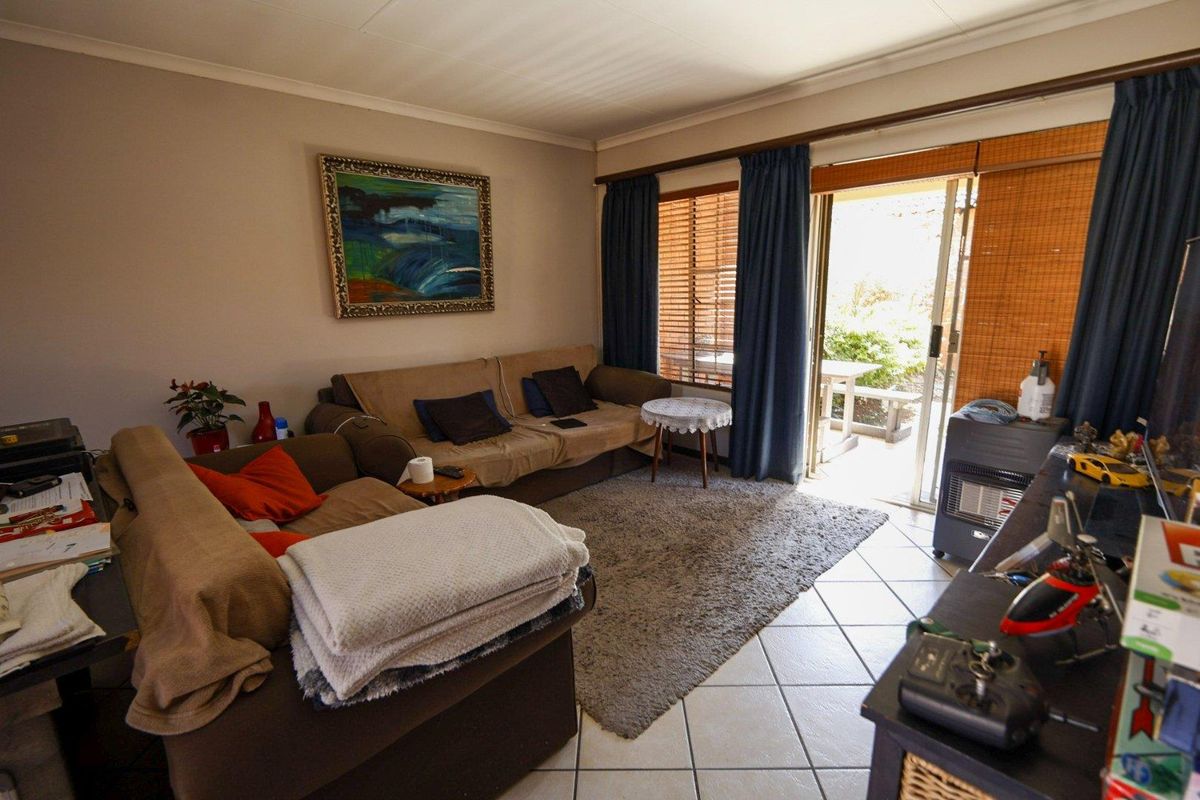 A comfortable living room featuring tiled flooring and a sliding glass door that provides direct access to the outdoor patio area.