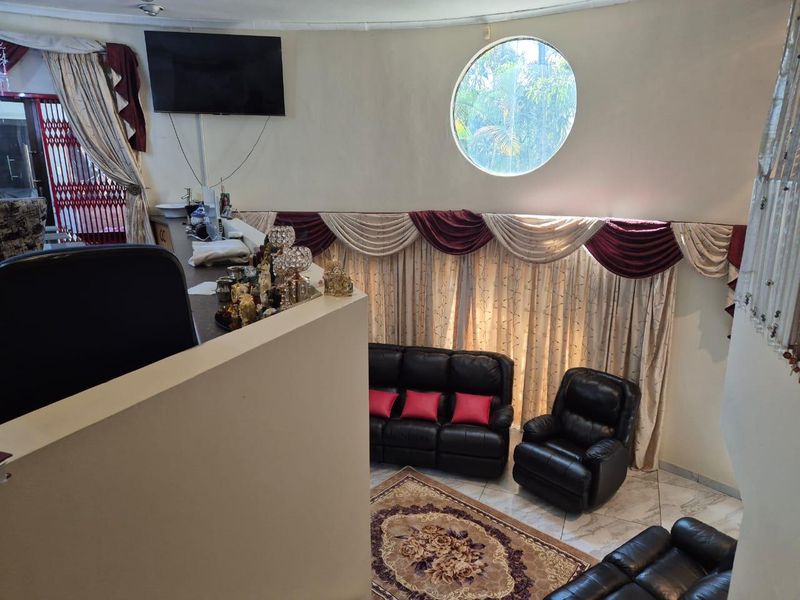 A living area featuring a unique circular porthole window, tiled flooring, and a built-in counter space overlooking the main seating area.