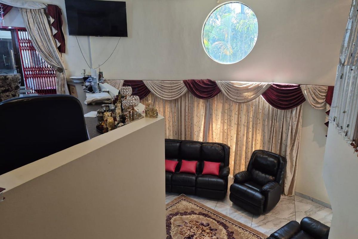 A living area featuring a unique circular porthole window, tiled flooring, and a built-in counter space overlooking the main seating area.