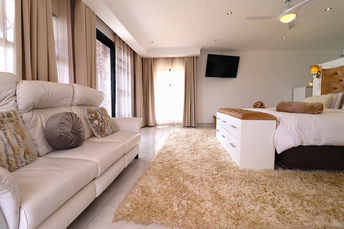 Spacious bedroom featuring tiled flooring, recessed ceiling lighting, a ceiling fan, and large windows with integrated curtain tracks.