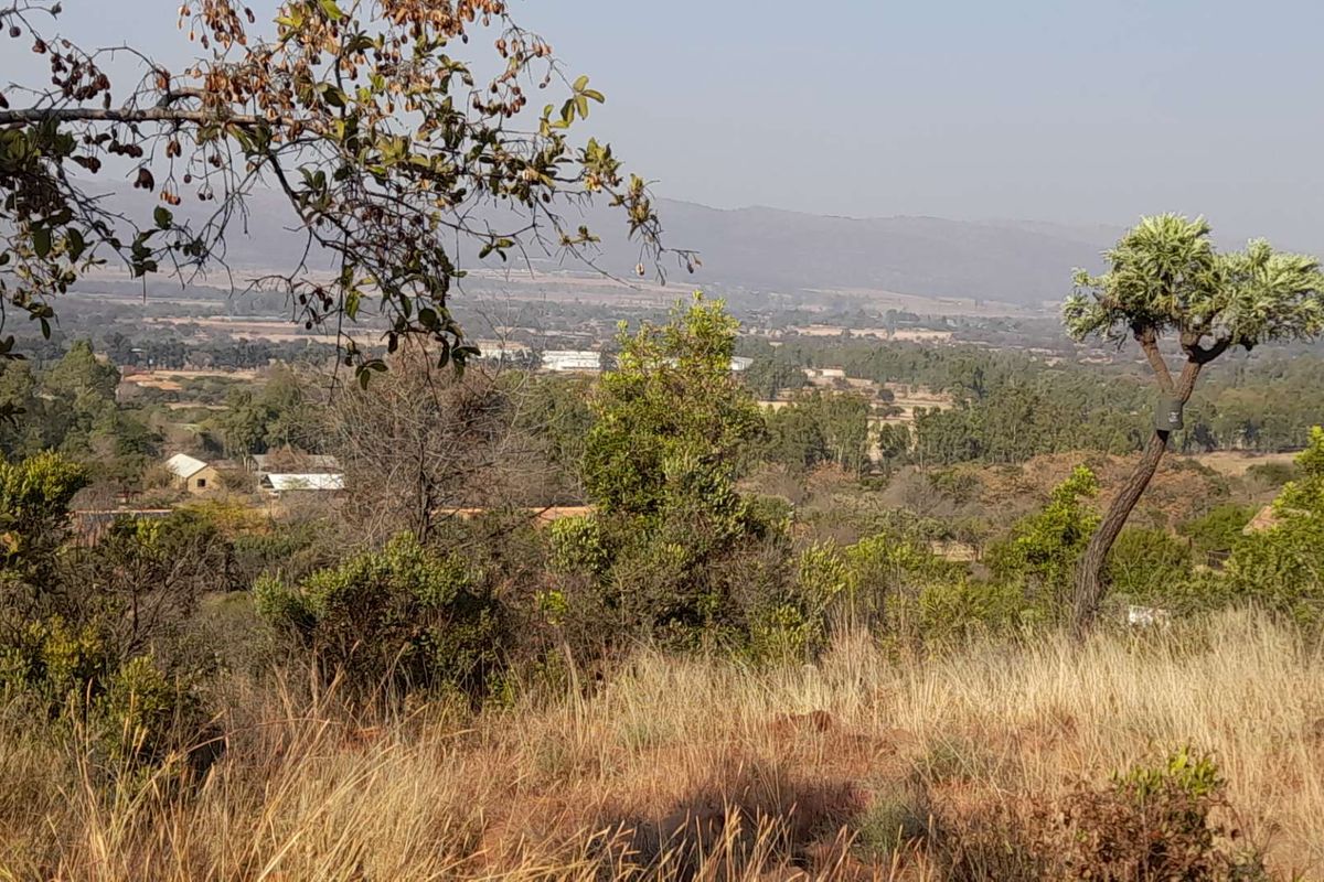A scenic elevated view overlooking the surrounding rural landscape and distant mountains, showcasing the natural beauty of the small holding property.