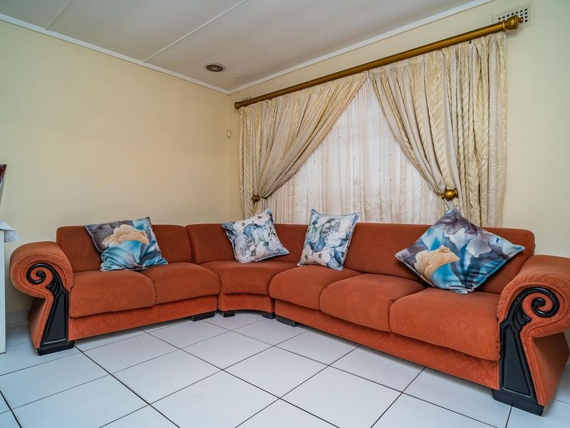 A living room area featuring white tiled flooring and neutral wall finishes, ready for a modern update.
