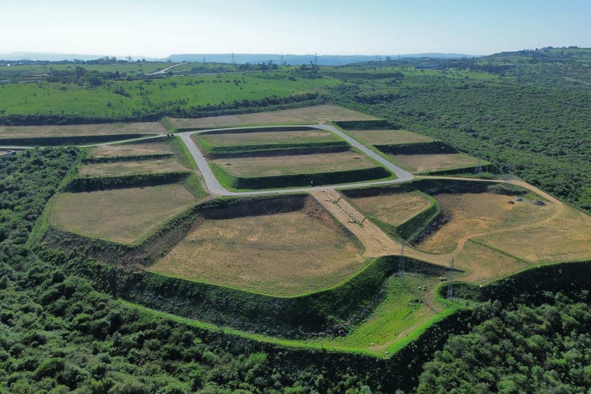 Aerial view of a large industrial development site featuring terraced plots and established internal road infrastructure surrounded by natural landscape.