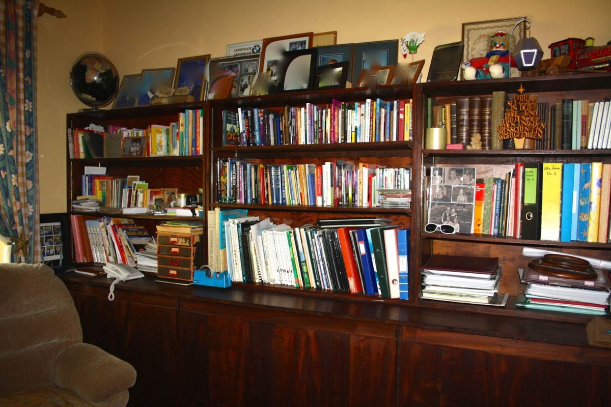 A room featuring extensive built-in dark wood cabinetry and shelving units, providing ample storage and display space.