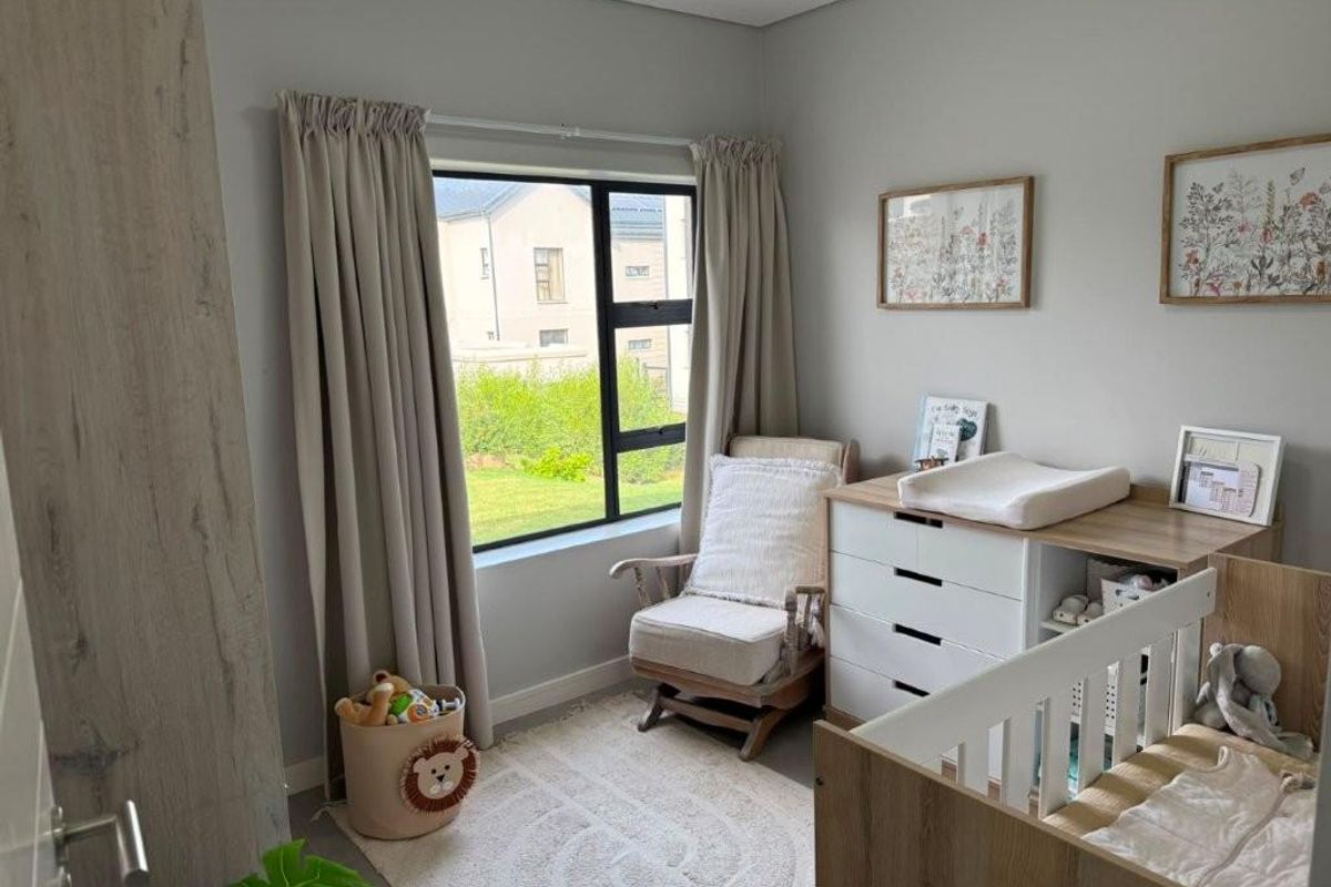 A well-maintained bedroom featuring neutral wall tones, large window with natural light, and built-in cabinetry.