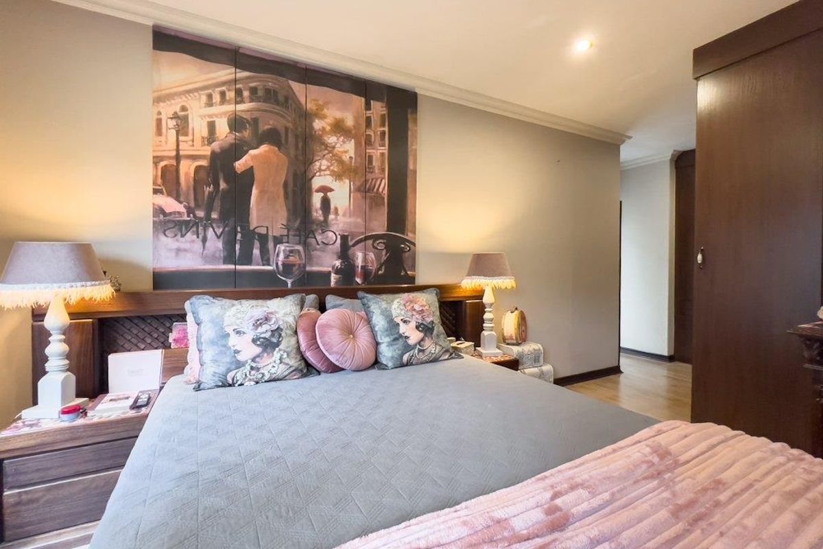 A well-maintained bedroom featuring built-in wooden cabinetry and integrated headboard lighting, offering a comfortable and functional living space.