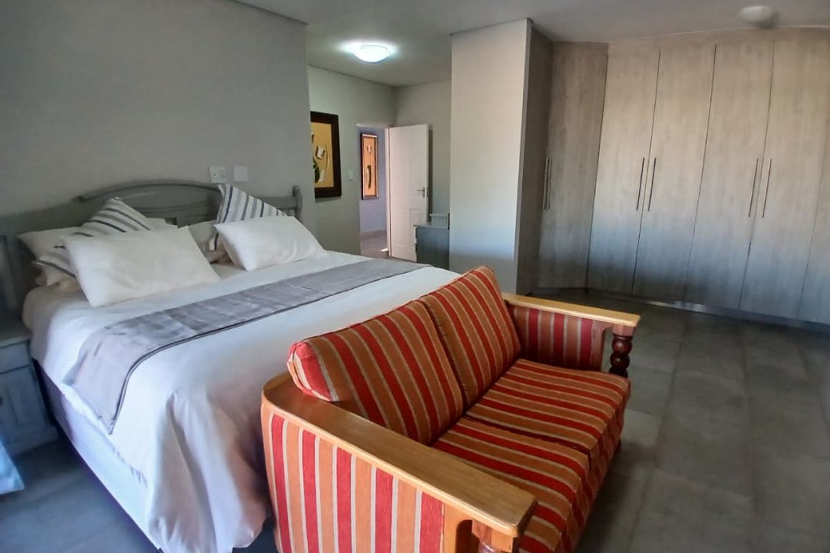 Spacious bedroom featuring neutral tiled flooring, ample built-in cupboard storage, and recessed ceiling lighting.