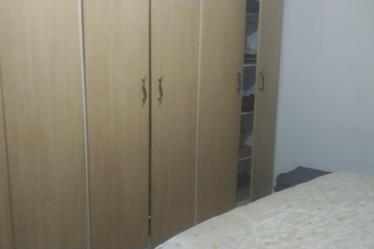 A bedroom featuring built-in wooden cabinetry providing ample storage space.