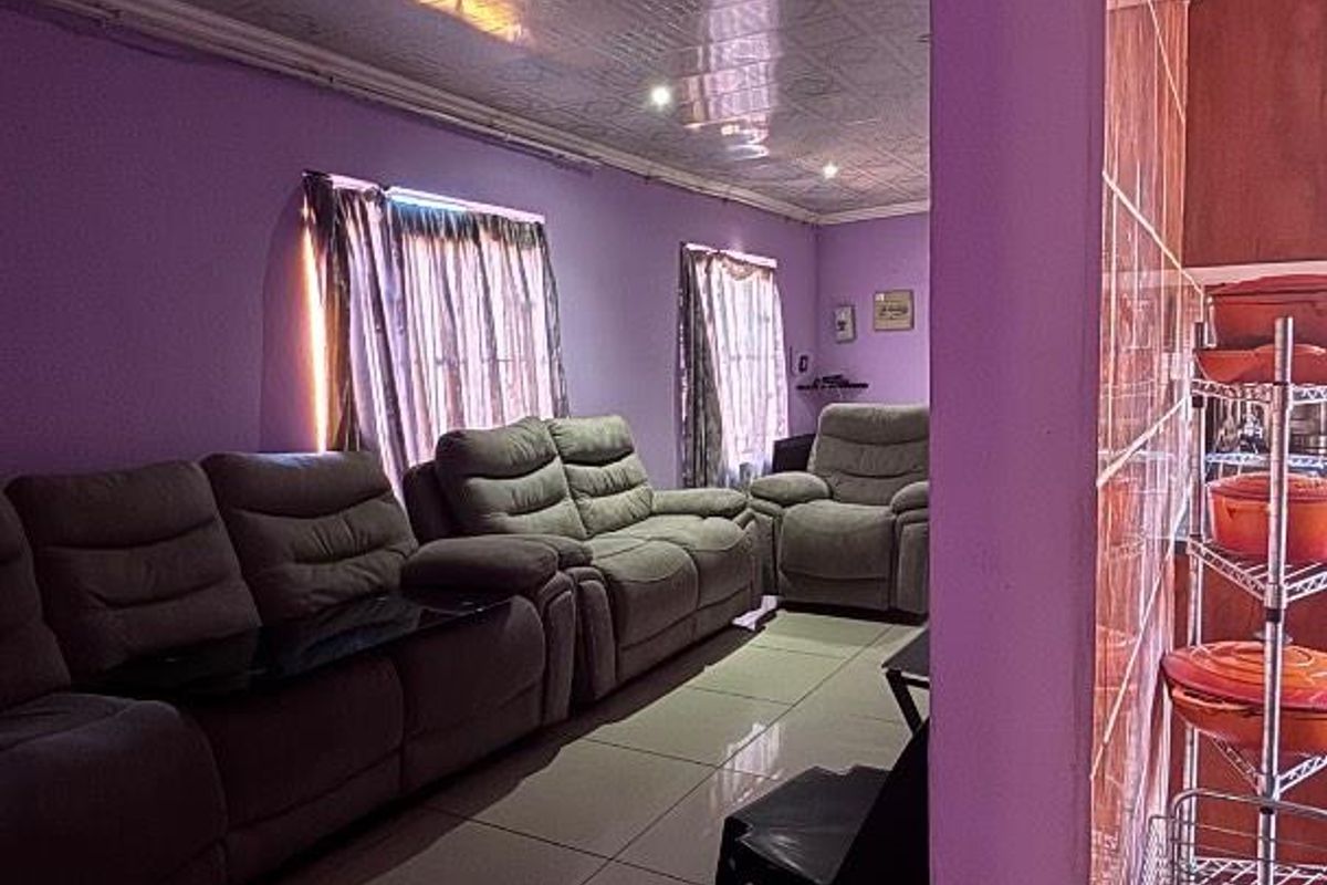 A living room featuring tiled flooring and a patterned ceiling, providing a functional space for relaxation.