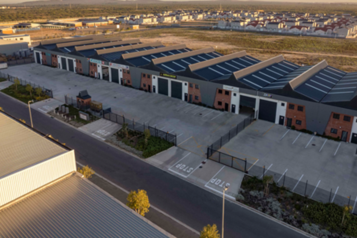 Aerial view of a modern industrial park featuring multiple warehouse units with roller shutter doors, paved parking areas, and secure perimeter fencing.