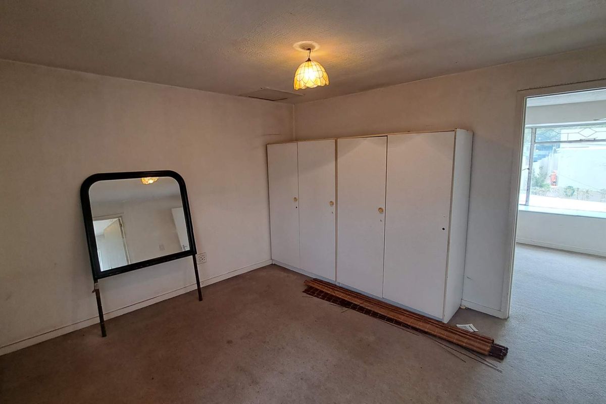 A bedroom featuring built-in cupboards and neutral wall finishes, offering a blank canvas for potential updates and interior design improvements.