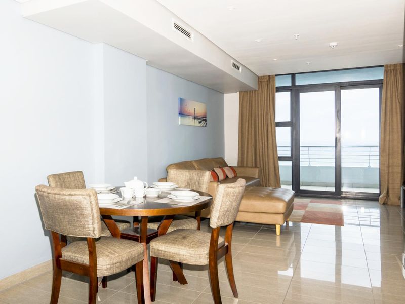Open plan living and dining area featuring tiled floors, recessed lighting, ducted air conditioning, and large sliding glass doors leading to a balcony.