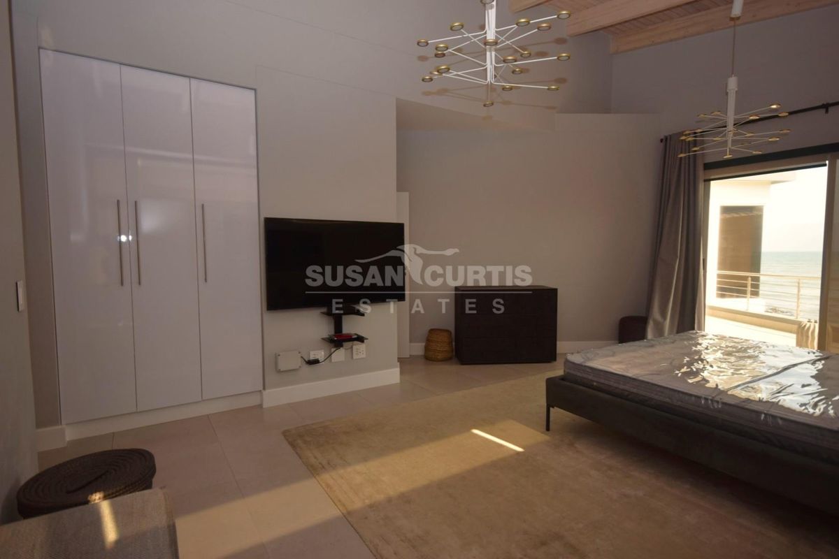 Spacious bedroom featuring built-in wardrobes, tiled flooring, and direct access to a balcony with scenic views.