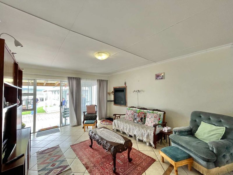 Spacious living room featuring tiled flooring, a built-in fireplace, and large sliding glass doors providing direct access to the outdoor patio area.