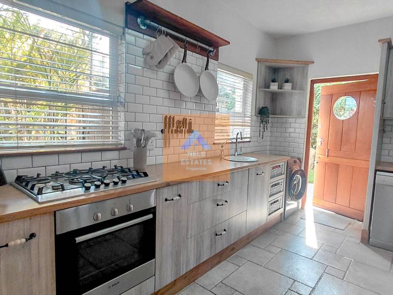 A functional kitchen featuring wooden countertops, subway tile backsplash, gas hob, built-in oven, and direct access to the exterior.