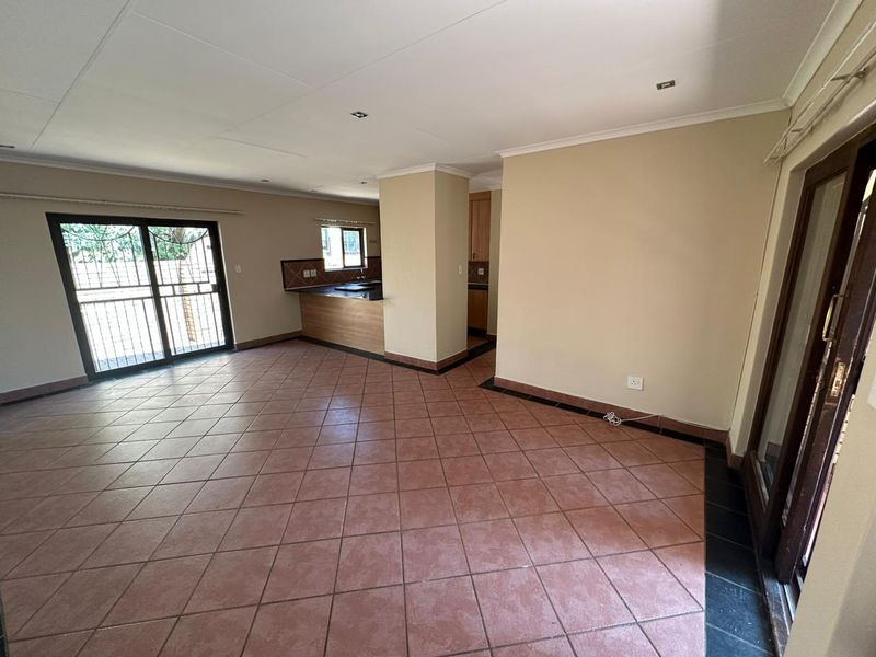 Spacious open-plan living area featuring ceramic tile flooring, recessed lighting, and direct access to outdoor spaces through sliding glass doors.