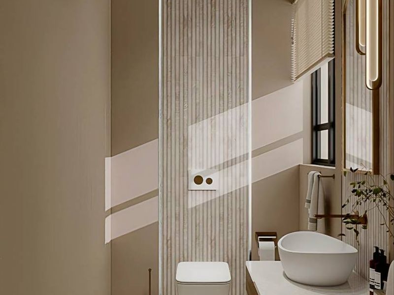 Modern bathroom featuring a wall-mounted toilet, floating vanity with a vessel sink, and elegant slatted wall paneling with warm ambient lighting.