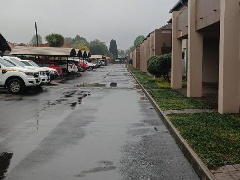 Exterior view of the apartment complex driveway featuring covered parking bays and paved access paths.