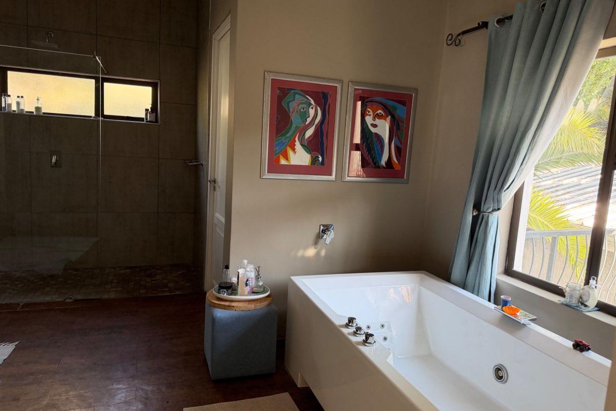 A well-appointed bathroom featuring a built-in bathtub and a separate walk-in shower with tiled finishes, offering a functional and comfortable space.