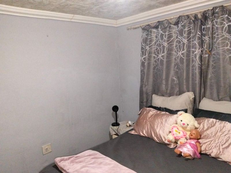 A bedroom featuring neutral wall finishes, ceiling cornicing, and an electrical wall socket.