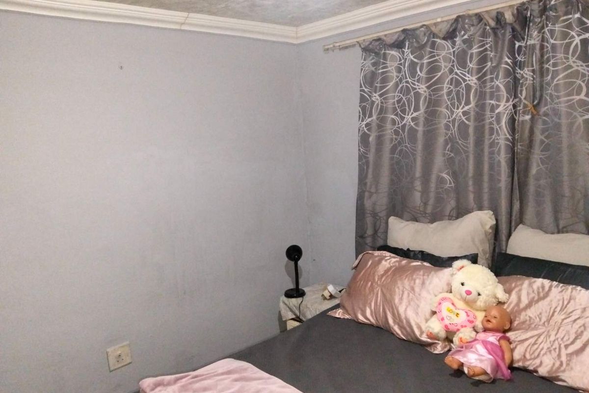 A bedroom featuring neutral wall finishes, ceiling cornicing, and an electrical wall socket.