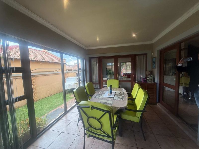 Enclosed patio area featuring tiled flooring, large sliding glass doors, and recessed ceiling lighting, providing a bright transition space to the garden.