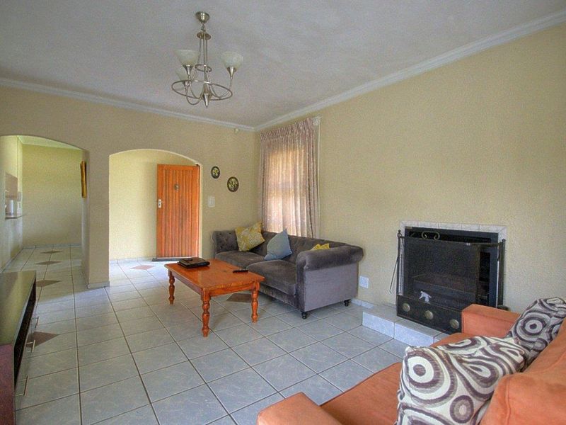 A living room featuring tiled flooring, a built-in fireplace, and an arched entryway leading to the rest of the home.